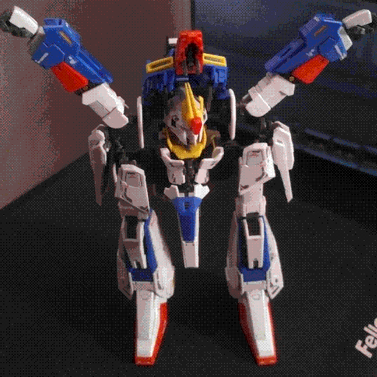 A photo of the RG Zeta Gundam model kit halfway through its transformation into the Waverider form. The legs have been splayed outwards, the chest piece has been flipped up, and the head has been retracted into the torso. Each arm is currently pointed upwards at a 45-degree angle, making the mech look like it's in a squat power pose.