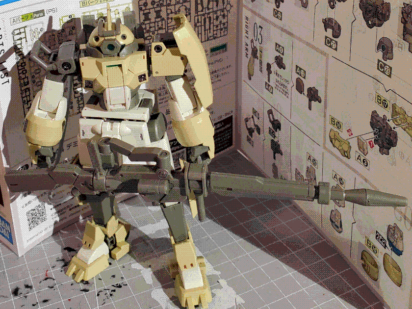 A photo of the high-grade Chuchu's Demi Trainer model kit. It is a squat, humanoid mech with beige and off-white armor panels, asymmetric shoulders, and a domed head with a single central monoeye. It has an extremely large beam rifle attached to a hardpoint mount and with a power cable feeding from the backpack. It is standing with its arms at its side.